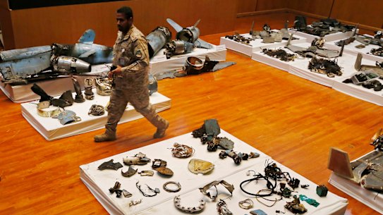A Saudi military officer walks by what was described as the remains of Iranian cruise missiles and drones used in an attack this weekend that targeted the heart of Saudi Arabia's oil industry. 