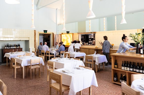 A sala de jantar de Julie possui tetos altos e luzes de cerâmica.