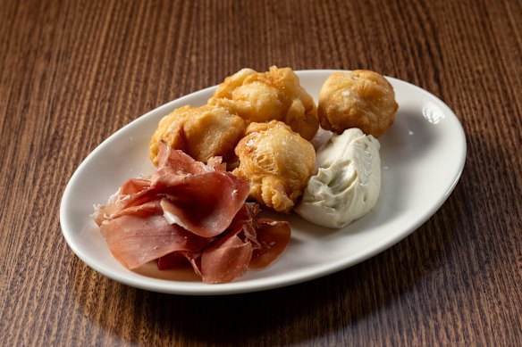 Coccoli (fried dough) with serrano ham and whipped ricotta.
