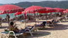 Tourists lounge under umbrellas along Patong Beach in Phuket.