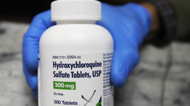 A pharmacist holds a bottle of the drug hydroxychloroquine in Oakland, California.