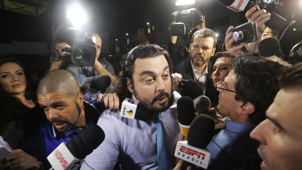 Danilo Garcia de Andrade, centre, lawyer for Najila Trindade, speaks with reporters as he arrives to a police station in Sao Paulo, Brazil, on Thursday.