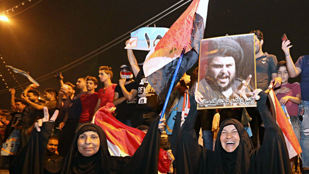Followers of Shiite cleric Muqtada al-Sadr, seen in the poster, celebrate in Tahrir Square, Baghdad, Iraq, on May 14, after it became apparent he would be pivotal in forming a new government.