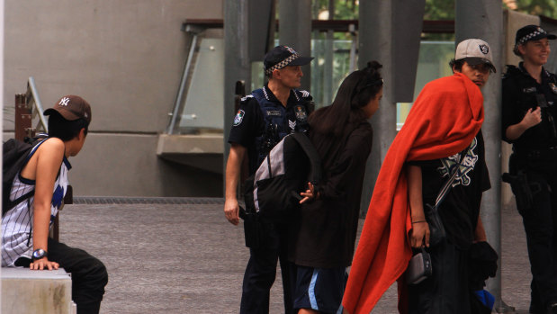 Police move a group of homeless young people on from King George Square in Brisbane.