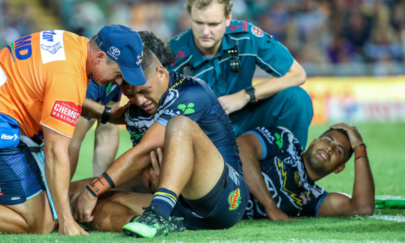 Play on: Cowboys duo John Asiata (left) and Nene Macdonald are attended to after their brutal collision last Friday night.