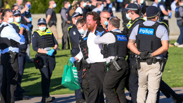 A man is taken away by police at the Shrine of Remembrance. 