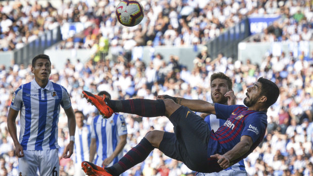 Ambitious: Barcelona's Luis Suarez attempts an overhead kick during the victory over Real Sociedad.