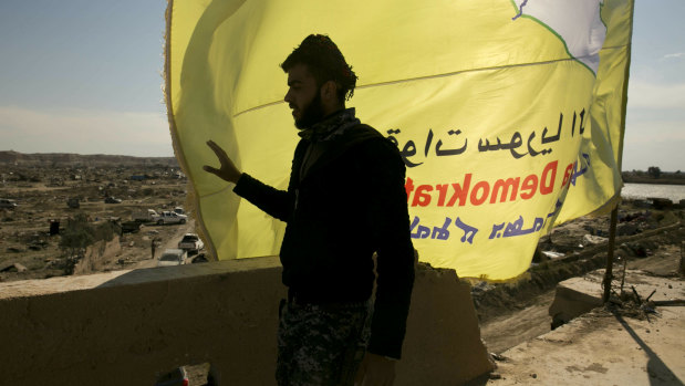 A US-backed Syrian Democratic Forces (SDF) fighter stands on a rooftop overlooking Baghouz, Syria, after the SDF declared the area free of Islamic State militants last month.