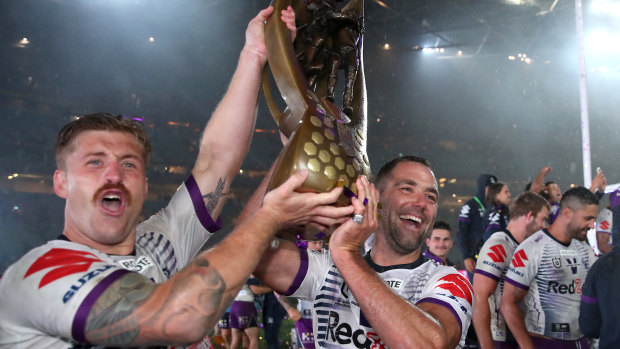 Cameron Munster and Cameron Smith lift up the trophy for the Melbourne Storm.