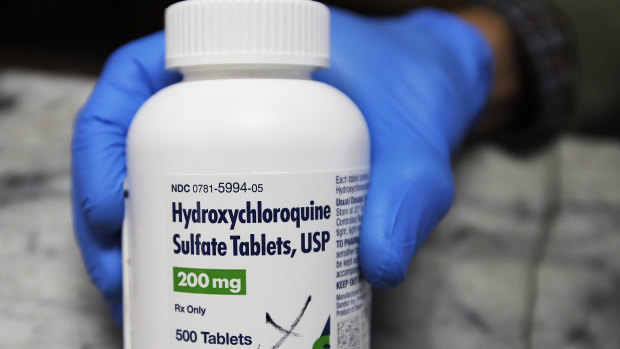 A pharmacist holds a bottle of the drug hydroxychloroquine in Oakland, California.