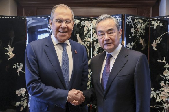 Wang Yi (right) and Russia’s Foreign Minister Sergei Lavrov shake hands in Jakarta on Thursday.