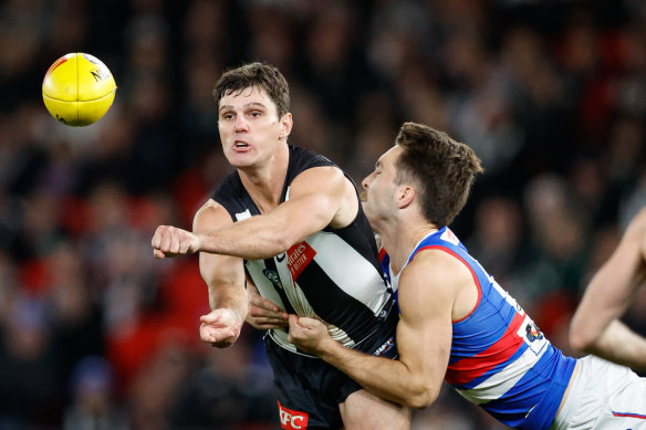 Lachie Schultz of the Magpies handpasses the ball.