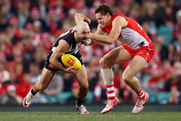 Steele Sidebottom of the Magpies is tackled by Hayden McLean of the Swans.