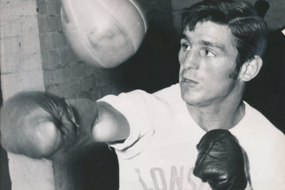 Australian boxing great Johnny Famechon pounds the speed ball in the gym.