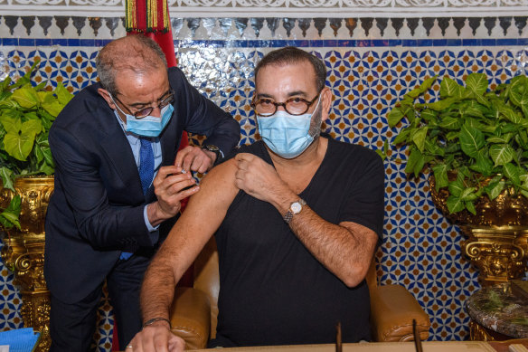 Morocco’s King Mohammed VI, right, receives the COVID-19 vaccine at the Royal Palace in Fez. 