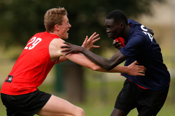 Andrew grapples with Toby Conway (left) during an AFL academy training session.