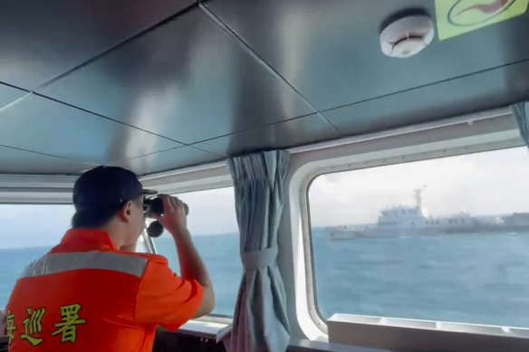 A member of the Taiwan Coast Guard monitors a China Coast Guard boat as it passes near the coast of Matsu Islands, Taiwan, in October.