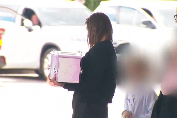 Stacey Gammage carries her baby daughter Willow’s casket from her children’s funeral service.