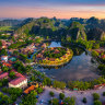 Discover a tapestry of jade-green rice paddies and muddy villages against a backdrop of blue hills. (Pictured: Tam Coc, just outside of Hanoi)