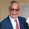 Britain’s Reform Party leader Nigel Farage poses with his poll card at a polling station.