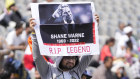 A cricket fan holds a placard to pay tribute to the Australian cricketer Shane Warne on the third day of the first test match between India and Sri Lanka in Mohali, India on Sunday.