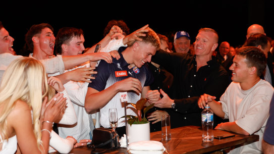 Caddy celebrates with family and friends after being picked up by the Bombers.