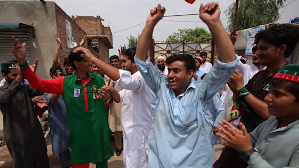 Supporters of politician Imran Khan dance to celebrate the victory of their party candidate, in Peshawar, Pakistan.