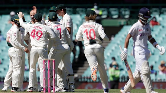 Australian players congratulate Nathan Lyon after dismissing India's Ajinkya Rahane on the final day of the third Test at the SCG.