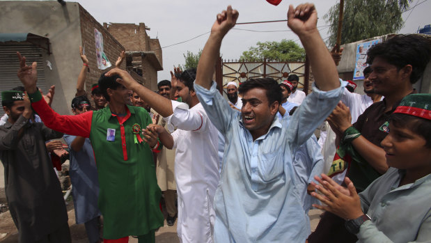 Supporters of politician Imran Khan dance to celebrate the victory of their party candidate, in Peshawar, Pakistan.