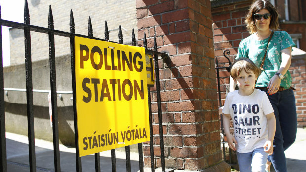 A woman and child leave a polling station after casting her vote in the referendum on the 8th Amendment of the Irish Constitution, in Knock.
