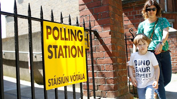 A woman and child leave a polling station after casting her vote in the referendum on the 8th Amendment of the Irish Constitution, in Knock.