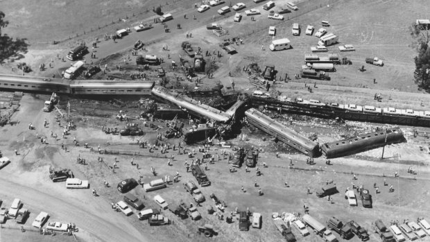 An aerial view of the crash scene with the Southern Aurora and freight train surrounded by rescue vehicles.