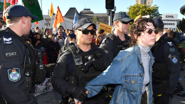 Police arrest a protester after activists blocked the corner of Margaret and William streets in Brisbane.