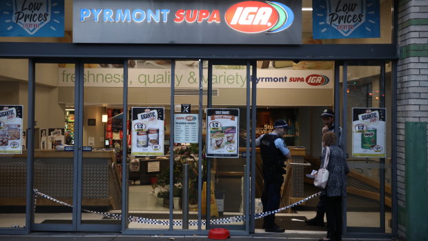 Police officers telling an IGA customer the store is closed. 