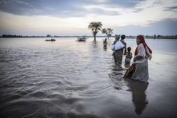 Pakistanis flee September monsoon flooding in Jalalpur Bhattian, Punjab province.