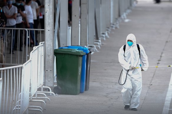 A worker disinfects a site where Beijing residents are being tested for COVID-19.