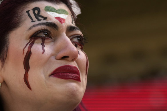 An Iranian woman cries after a security guard seized her flag reading “Woman Life Freedom” before the start of the Wales v Iran match at the Ahmad Bin Ali Stadium in Al Rayyan, Qatar, on Friday.