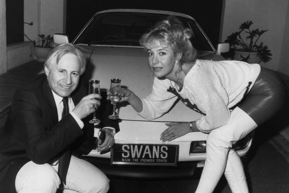 Dr Edelsten and wife Leanne celebrate next to their Porsche after buying the Sydney Swans.