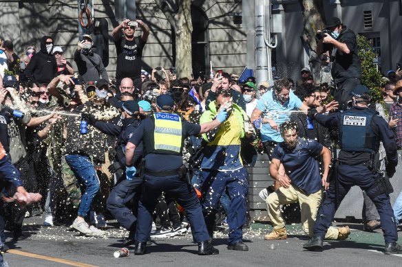 Victoria Police use capsicum spray on protesters on Spring St on Saturday.