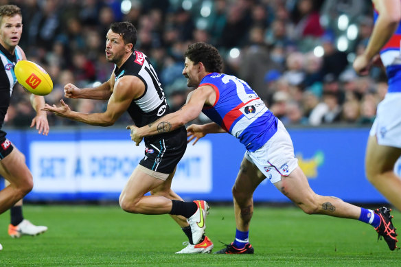 Travis Boak handballs as Tom Liberatore moves in to tackle.