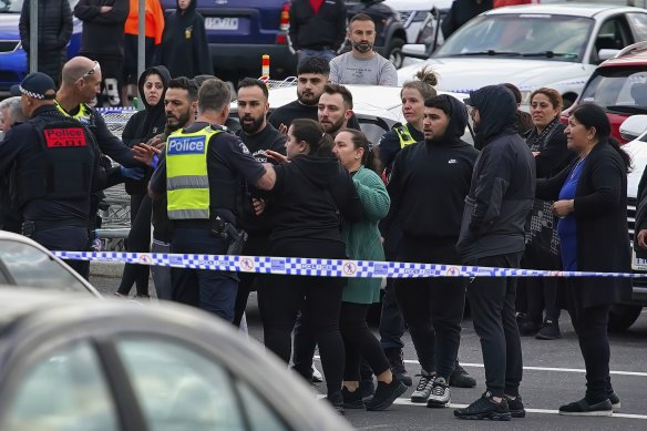 People talking to police at the scene of the shooting.