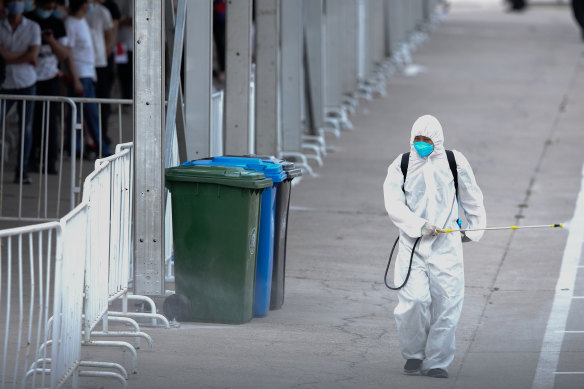 A worker disinfects a site where Beijing residents are being tested for COVID-19.