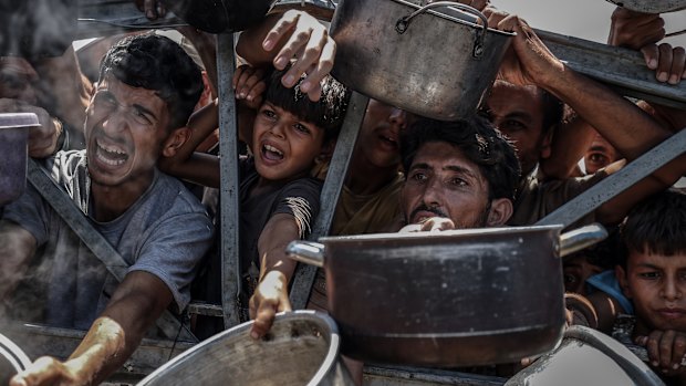 Palestinians, including children, line up this week in Gaza City to receive food.  