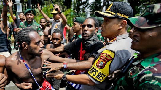Papuan protesters scuffle with police and soldiers near the presidential palace in Jakarta on August 22, 2019.