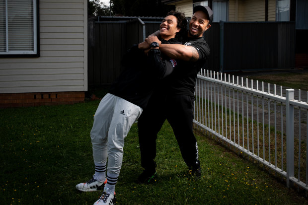 Martin wrestles with his son Jarome outside their Dharruk home during the week.