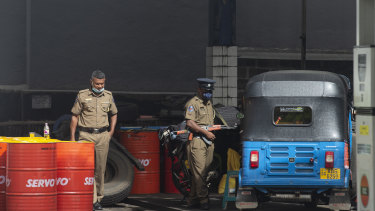 Police officers stand guard at a petrol station in Colombo, Sri Lanka, on Monday, May 16, 2022.