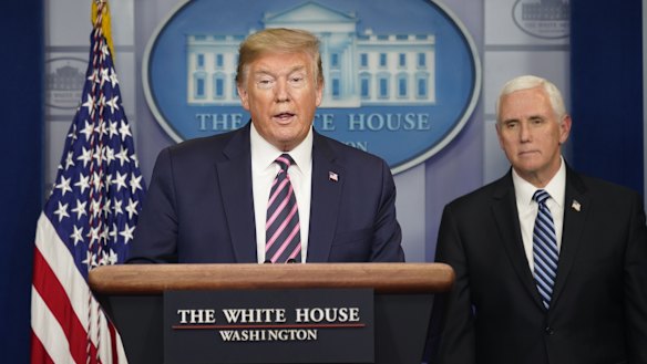 Donald Trump speaks as Vice-President Mike Pence looks on. The White House is moving against the WHO on several fronts.