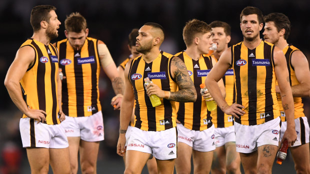 Dejected Hawks leave the field after losing to Essendon.