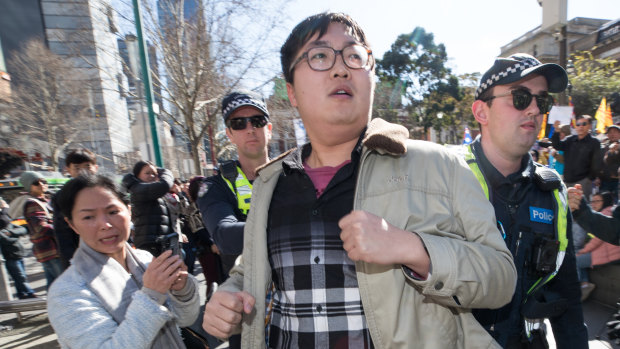Police remove a supporter of Beijing on Saturday morning during the second rally in two days in Melbourne in support of Hong Kong democracy protesters.