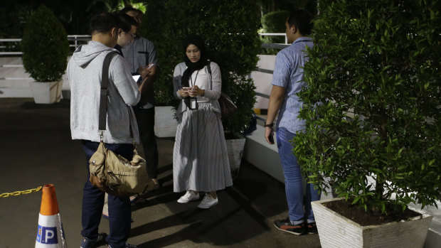 People gather as they evacuate from a building.